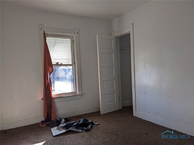 unfurnished bedroom with dark carpet