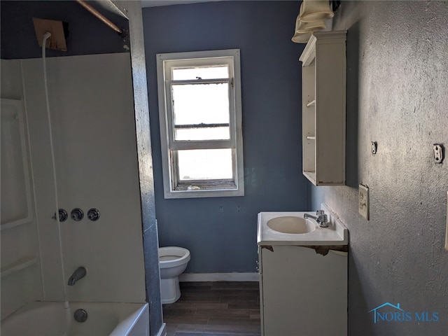 full bathroom with vanity, hardwood / wood-style floors, tub / shower combination, and toilet