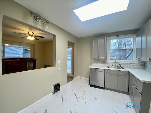 kitchen with gray cabinets, dishwasher, and plenty of natural light