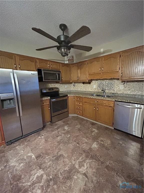 kitchen featuring ceiling fan, sink, appliances with stainless steel finishes, and tasteful backsplash