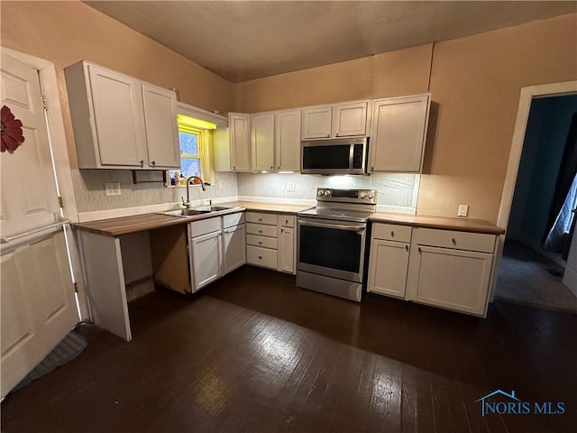 kitchen featuring dark hardwood / wood-style floors, sink, white cabinetry, and stainless steel appliances