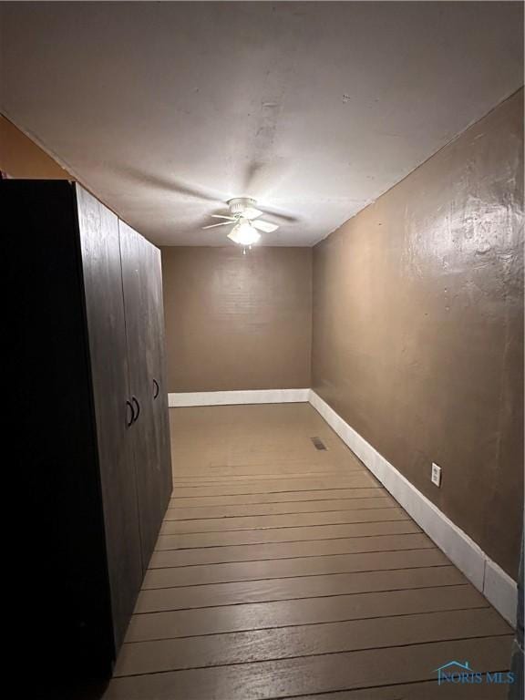 interior space with ceiling fan and wood-type flooring