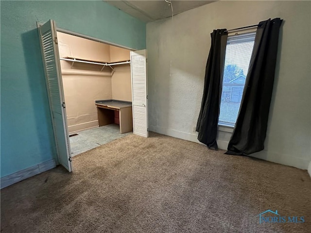 unfurnished bedroom with light colored carpet and a closet