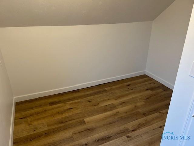 interior space with dark hardwood / wood-style floors and lofted ceiling