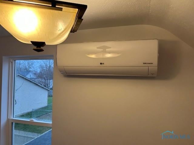 room details featuring an AC wall unit and a textured ceiling