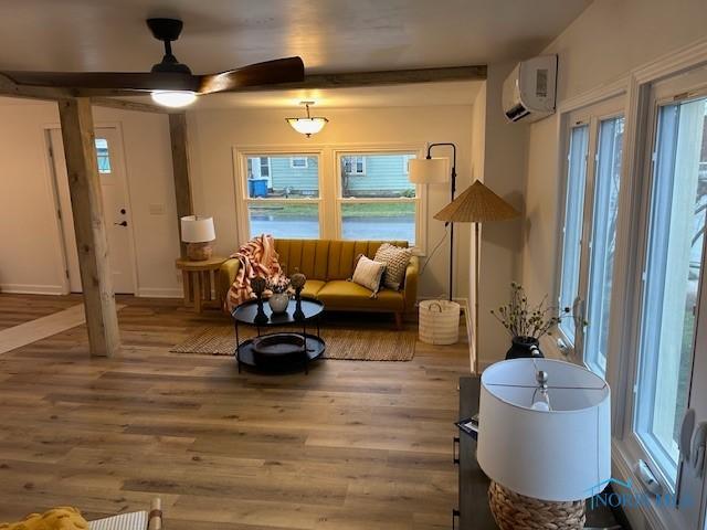 interior space with hardwood / wood-style floors, a wall mounted AC, and ceiling fan