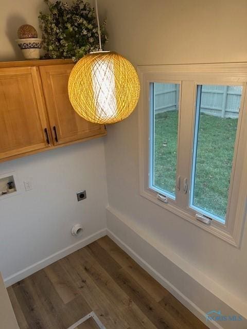 washroom with electric dryer hookup, cabinets, dark wood-type flooring, and washer hookup