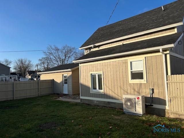 rear view of house with a yard and ac unit