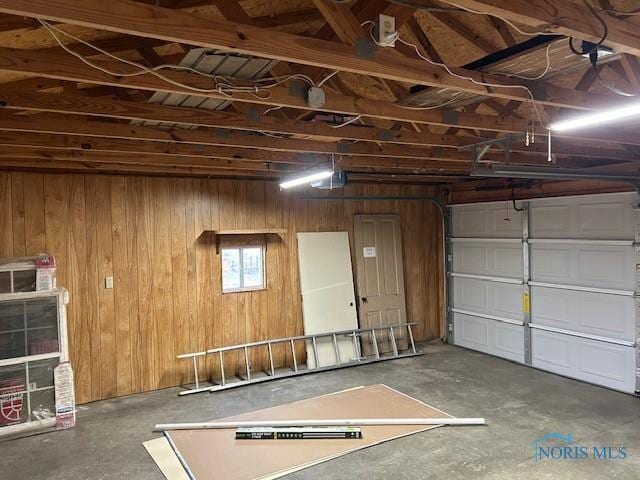 garage featuring wood walls and a garage door opener