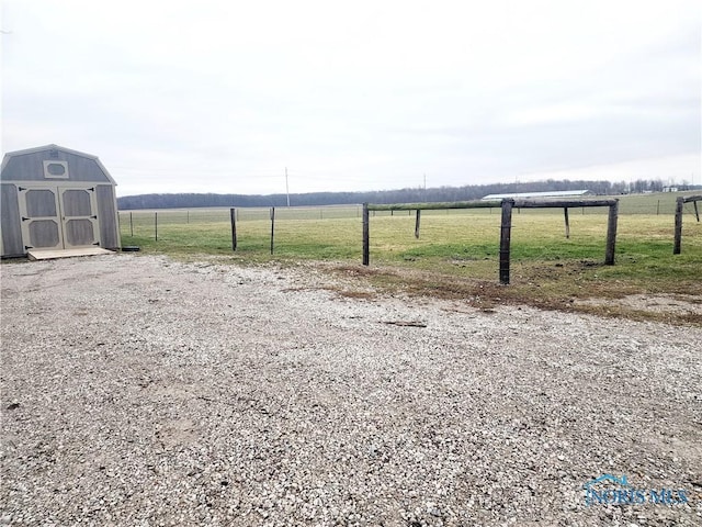 view of yard featuring a rural view and a storage shed