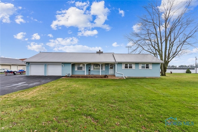 ranch-style house featuring covered porch, a garage, and a front yard