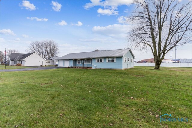 single story home with a water view, a front yard, and a garage