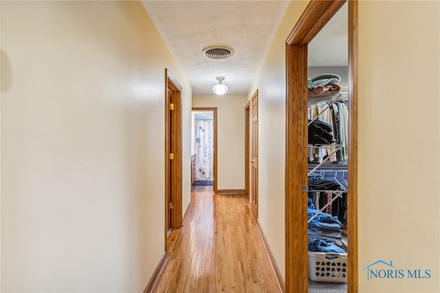 hallway with light hardwood / wood-style floors