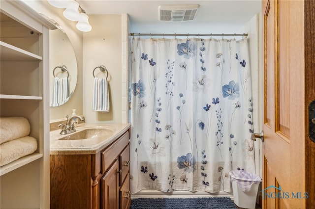 bathroom with curtained shower and vanity