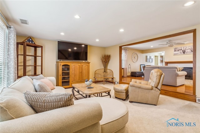 living room with light colored carpet and ceiling fan