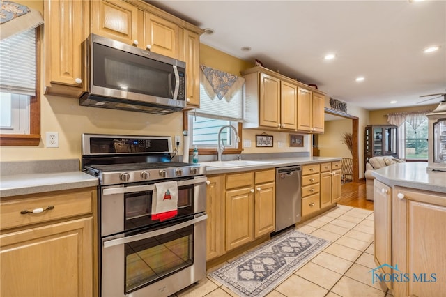 kitchen featuring a healthy amount of sunlight, light tile patterned flooring, and appliances with stainless steel finishes