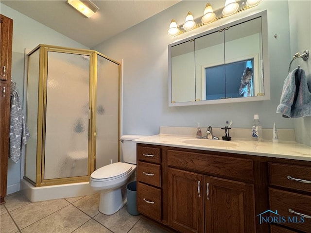 bathroom featuring tile patterned flooring, vanity, toilet, and an enclosed shower