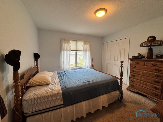 bedroom with a textured ceiling, carpet floors, and a closet