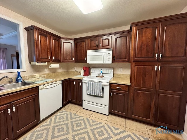 kitchen with a textured ceiling, white appliances, light tile patterned floors, and sink