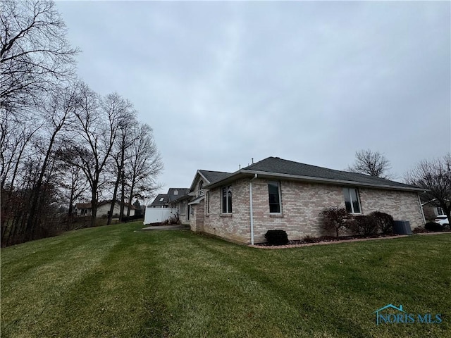 view of home's exterior with a lawn and cooling unit