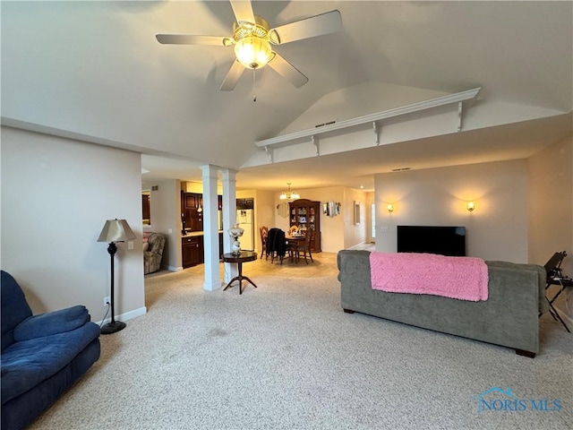 carpeted living room with ceiling fan with notable chandelier and vaulted ceiling