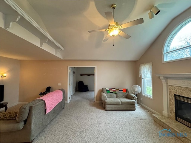 living room featuring carpet flooring, vaulted ceiling, ceiling fan, and a premium fireplace