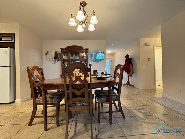 tiled dining space featuring a chandelier