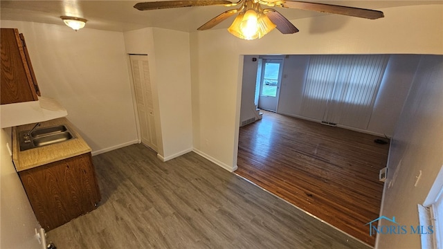 interior space featuring dark hardwood / wood-style floors, ceiling fan, and sink