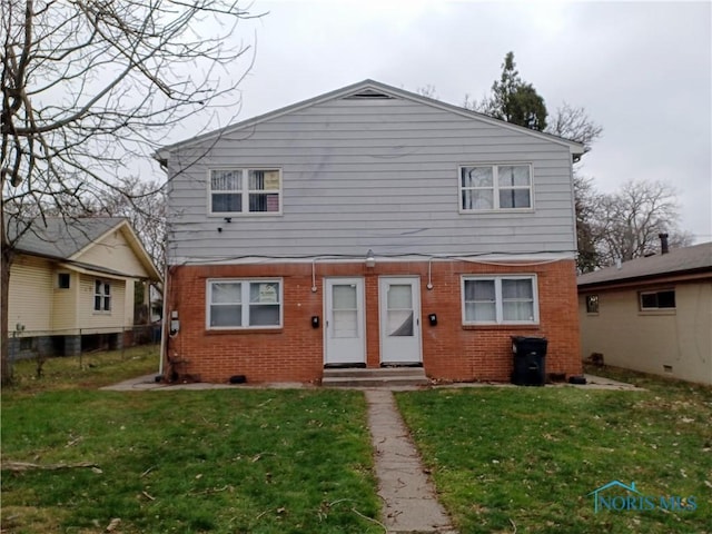 1719 W Bancroft St, Toledo, OH 43606 - rear view of property featuring brick siding and a lawn