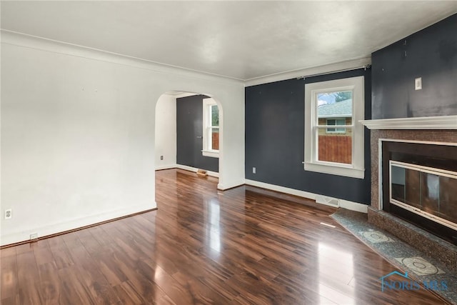 unfurnished living room with dark hardwood / wood-style floors, a premium fireplace, and ornamental molding