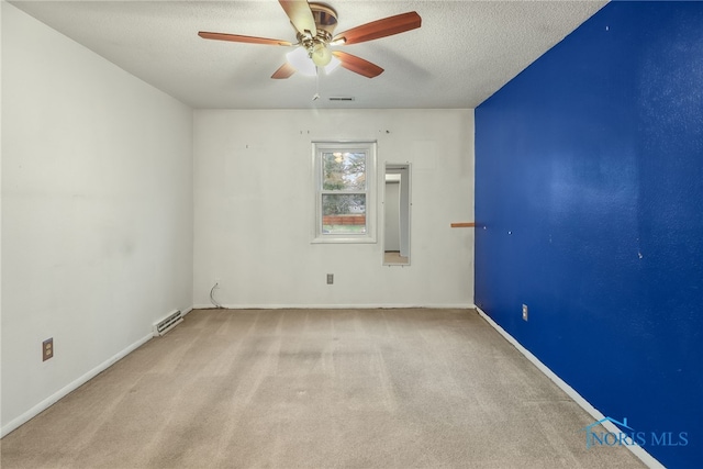 spare room with a textured ceiling, ceiling fan, and light carpet