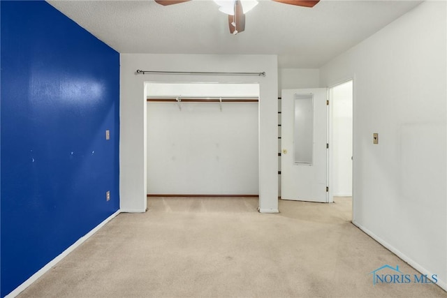 unfurnished bedroom with ceiling fan, a closet, and light colored carpet