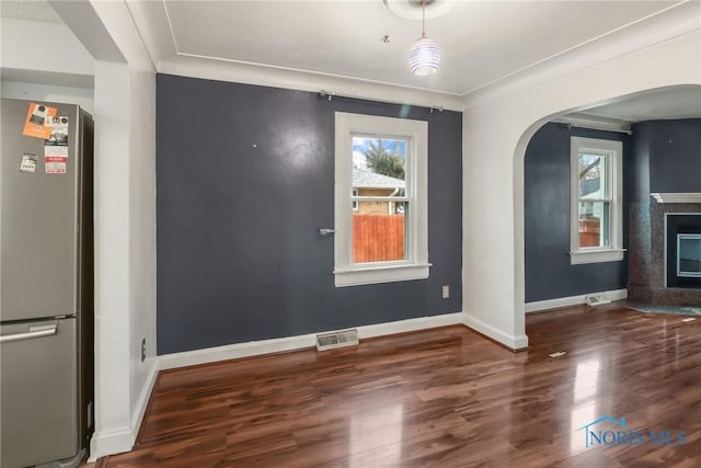 unfurnished dining area with dark hardwood / wood-style floors and crown molding