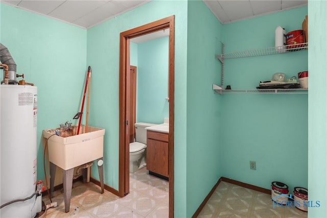 bathroom featuring vanity, toilet, and water heater