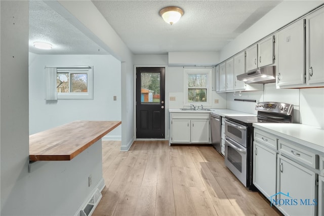 kitchen featuring white cabinetry, a textured ceiling, and appliances with stainless steel finishes