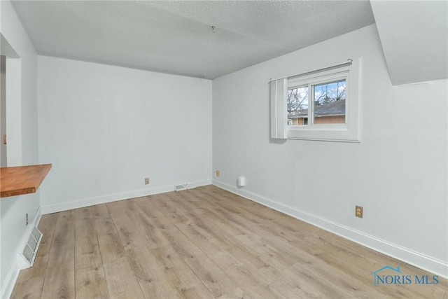 interior space with a textured ceiling and light wood-type flooring