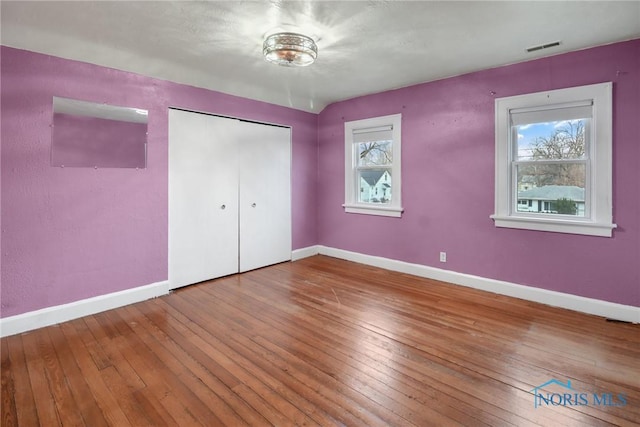 unfurnished bedroom featuring a closet and hardwood / wood-style floors