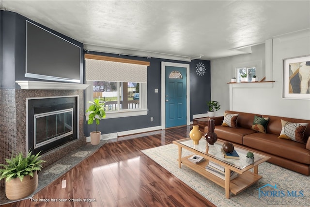 living room featuring a wealth of natural light, a fireplace, and dark hardwood / wood-style floors