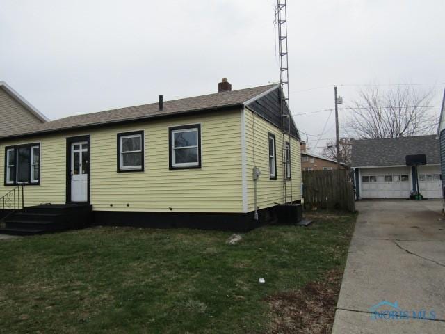 view of front of house featuring an outbuilding, a garage, and a front lawn