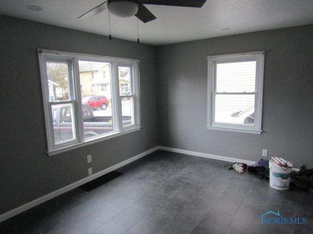 spare room with ceiling fan and a healthy amount of sunlight