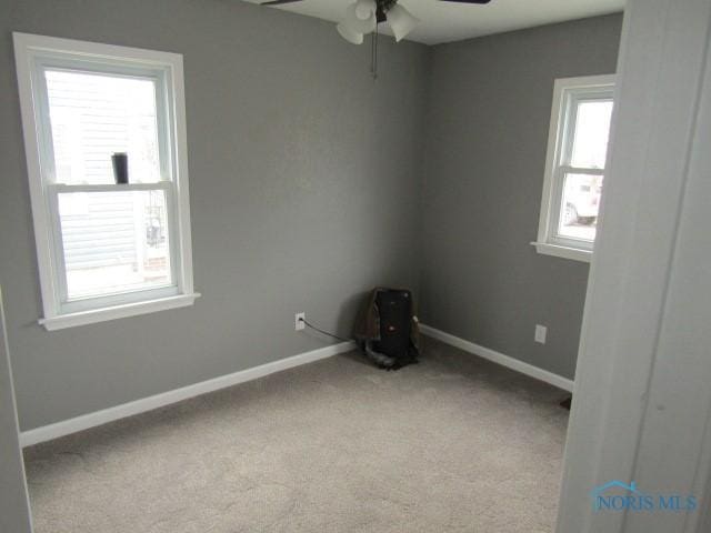 carpeted spare room with ceiling fan