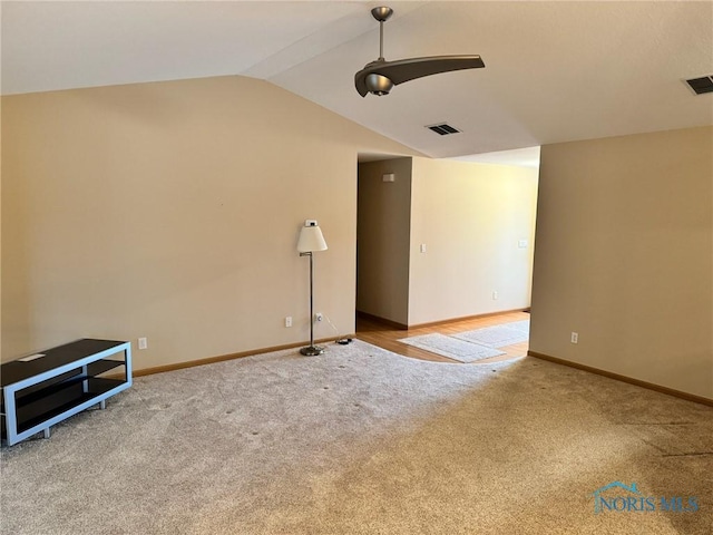 carpeted spare room with ceiling fan and lofted ceiling