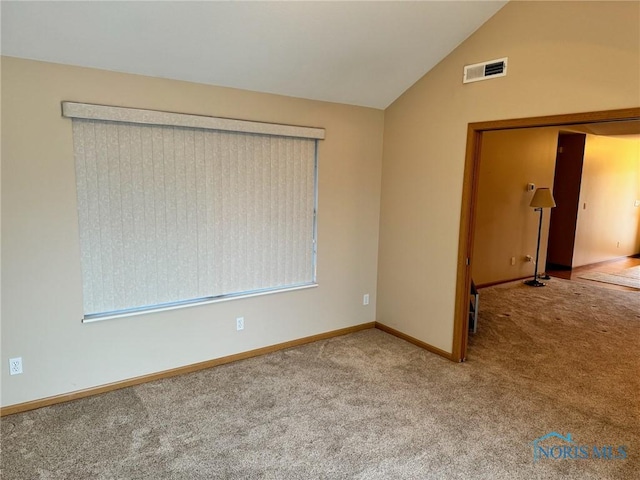 unfurnished room with carpet flooring and lofted ceiling