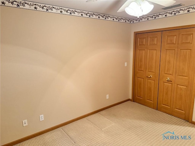 unfurnished bedroom with carpet flooring, ceiling fan, and a closet