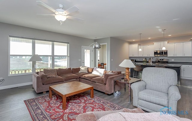 living room with dark hardwood / wood-style floors, ceiling fan, and a healthy amount of sunlight