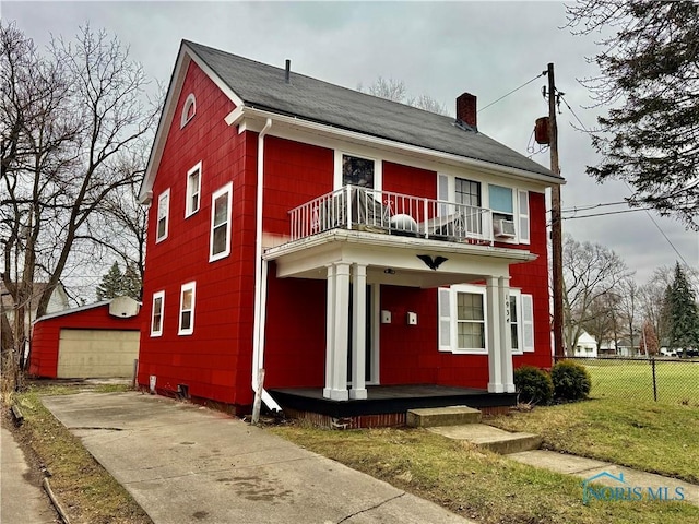 view of front of property with a garage, a front yard, a balcony, an outbuilding, and covered porch