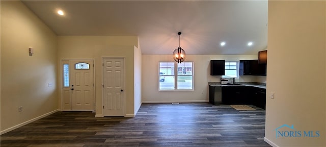 kitchen featuring lofted ceiling, decorative light fixtures, and dark wood-type flooring