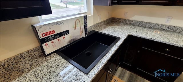 kitchen with dark brown cabinets, sink, and hardwood / wood-style floors