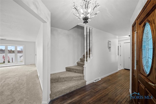 foyer entrance featuring dark hardwood / wood-style floors and a notable chandelier