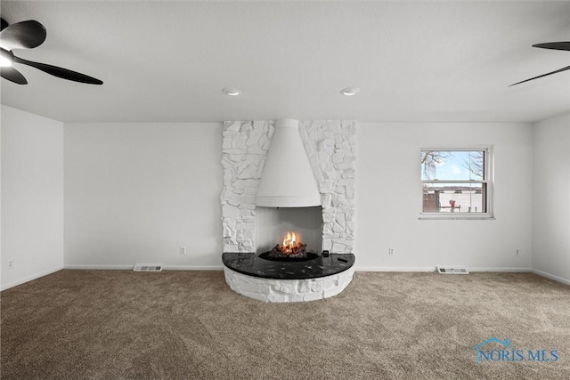 unfurnished living room with a fireplace, carpet, and ceiling fan